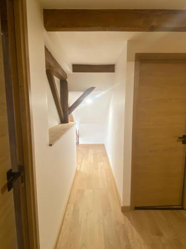 a hallway with a door and a room with wooden beams at Grange rénovée, 6 minutes du Lac d'Annecy vue sur le Mont-Blanc in Giez