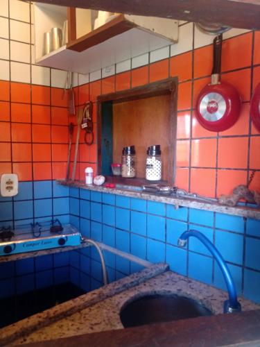 Il comprend une cuisine dotée d'un mur en carrelage bleu et orange. dans l'établissement Cavalos Marinhos Hospedagem, à Cairu