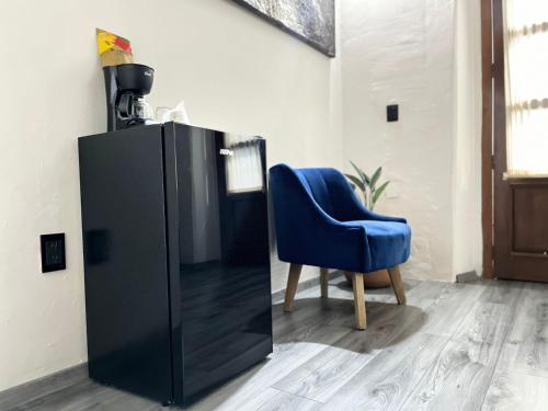 a blue chair sitting next to a black cabinet at BKL Hotel in Oaxaca City