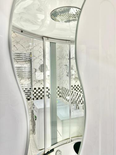 a mirror in a bathroom with a white room at Full Comfort Apartment at Chavchavadze in Tbilisi City