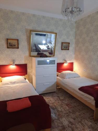 a bedroom with two beds and a mirror on the wall at Noclegi Sylana in Kobyłka