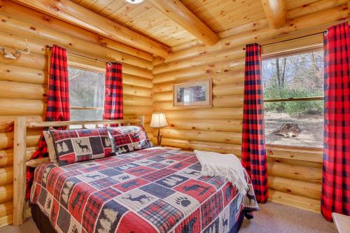 MerrillanにあるMerrillan Cabin with Fire Pit Less Than 1 Mi to Lake Arbutusの丸太小屋のベッドのある寝室