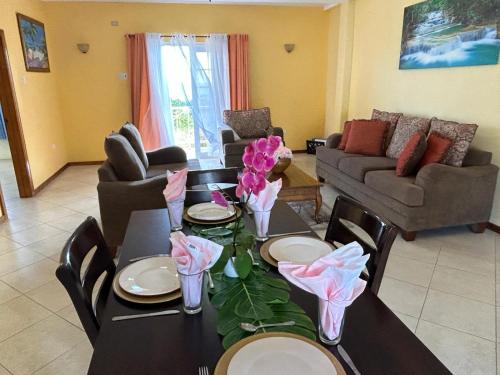 a living room with a table with flowers on it at Faith's Villa Tobago in Diamond