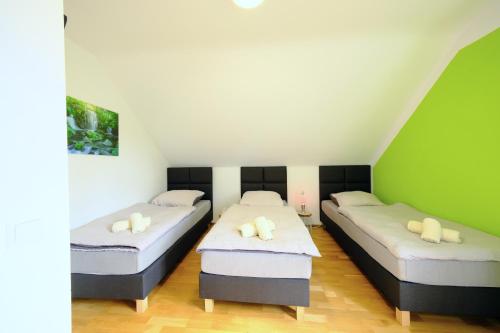two beds in a room with green walls at HappyBnB - Stilvolles, naturgelegenes Apartment mit Blick auf den Mittellandkanal und die Wasserstadt Hannover - Kamin, Parken und Spielplatz in Hannover