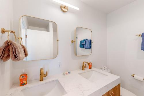 La salle de bains blanche est pourvue d'un lavabo et d'un miroir. dans l'établissement Riverfront Oasis, à Salyer