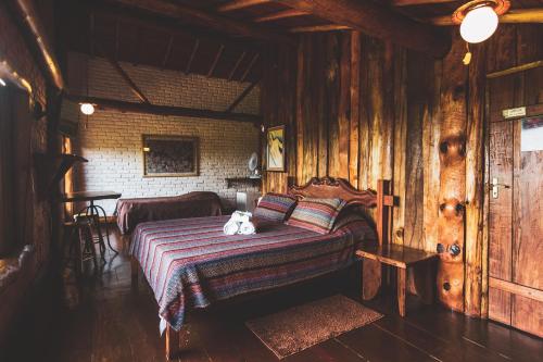 Un dormitorio con una cama con un osito de peluche. en Pousada Alto dos Manacás Chalés e Restaurante en Lima Duarte
