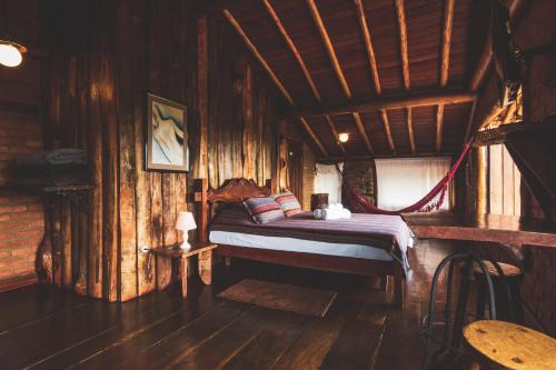 sypialnia z łóżkiem w drewnianym domku w obiekcie Pousada Alto dos Manacás Chalés e Restaurante w mieście Lima Duarte