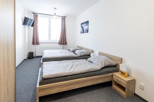 two beds in a room with a window at Penzion Fiesta in Prostějov