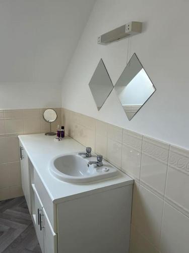a bathroom with a white sink and a mirror at Annie's Hideaway in Chapel Saint Leonards