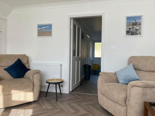 a living room with two chairs and a table at Annie's Hideaway in Chapel Saint Leonards