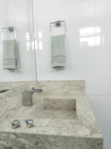 a bathroom with a sink and a mirror and towels at Quarto Nostalgia in Rio Branco