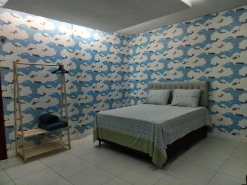 a bedroom with a bed and a wall covered in fishes at Quarto Nostalgia in Rio Branco