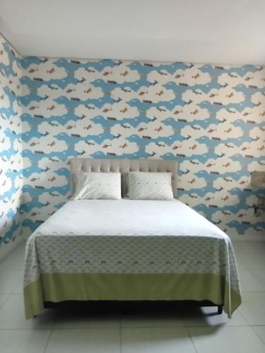 a bedroom with a fish patterned wall with a bed at Quarto Nostalgia in Rio Branco
