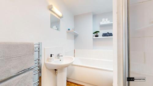 ein weißes Bad mit einem Waschbecken und einer Dusche in der Unterkunft Cardiff centre flat with free parking in Cardiff