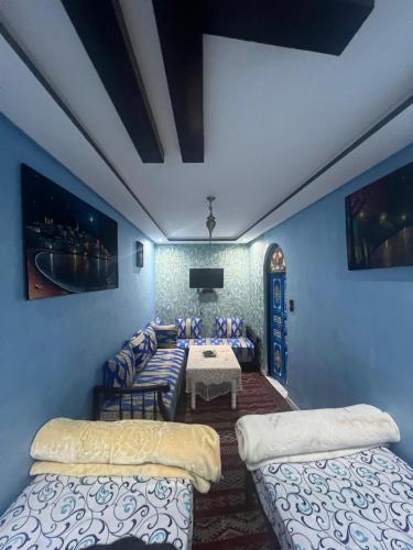 a room with two beds and a table in it at Dar Ghita Medina in Rabat