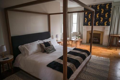 a bedroom with a canopy bed and a fireplace at Canandaigua Guesthouse in Canandaigua