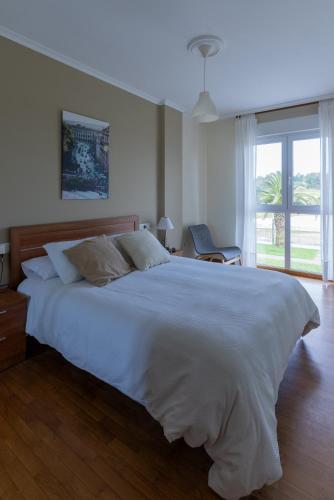 a large white bed in a bedroom with a window at Puente Romana in San Ciprián