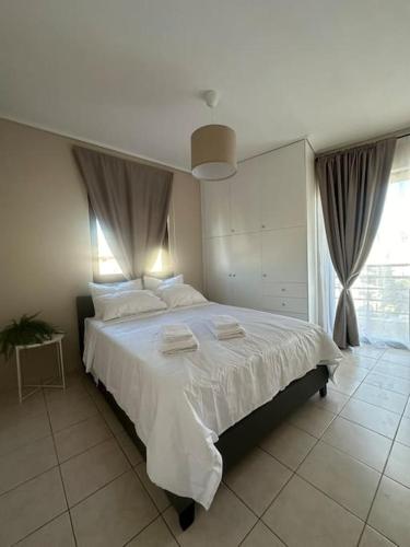 1 dormitorio con 1 cama grande con sábanas blancas en Minimalist Athenian apartments n7, en Atenas