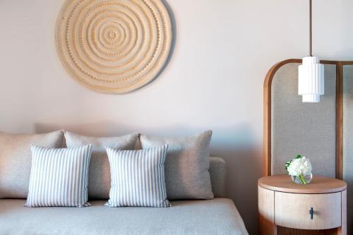 a couch with striped pillows and a clock on the wall at The Ritz-Carlton Tenerife, Abama in Guía de Isora