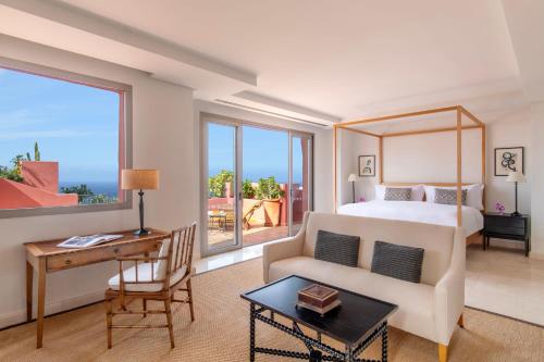 a hotel room with a bed and a desk and a window at The Ritz-Carlton Tenerife, Abama in Guía de Isora