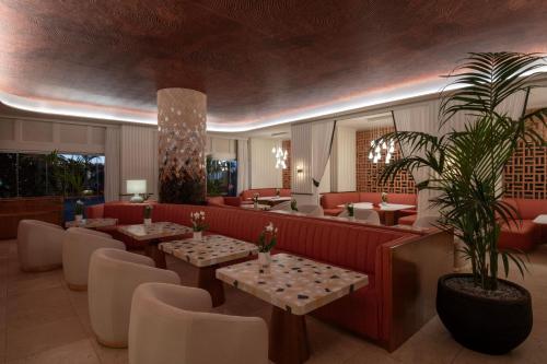 a restaurant with tables and couches and a potted plant at The Ritz-Carlton Tenerife, Abama in Guía de Isora