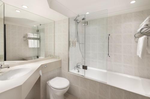 a bathroom with a shower and a toilet and a sink at Glasgow Marriott Hotel in Glasgow