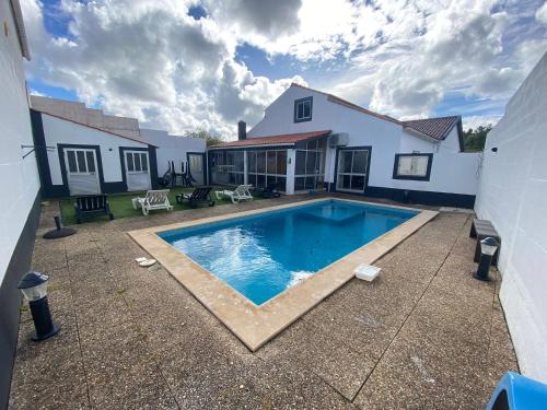 a swimming pool in the backyard of a house at Canto Celeste in Alcobaça