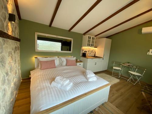 a bedroom with a bed with white sheets and pink pillows at ToVouno in Plaka