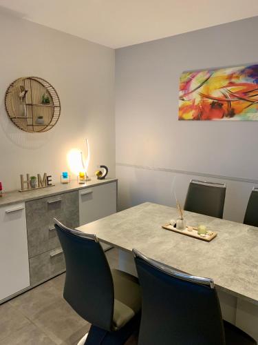 une pièce avec une table, des chaises et un tableau dans l'établissement Grand F3 - Emplacement d'or proche Paris et Versailles, à Plaisir