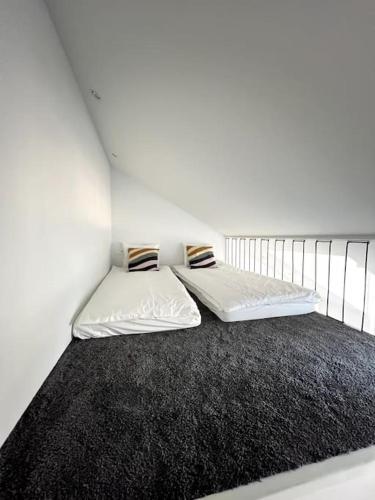 a bedroom with a bed with a black rug at Brand-new Central Loft in Vilnius