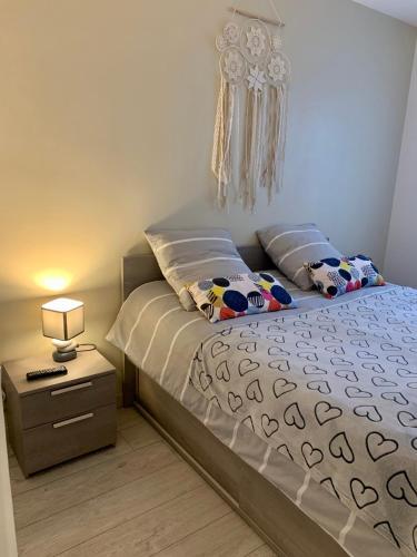 1 dormitorio con 1 cama y mesita de noche con lámpara en Grand F3 - Emplacement d'or proche Paris et Versailles, en Plaisir
