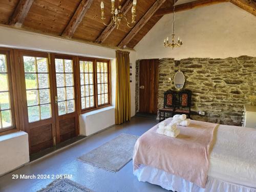 1 dormitorio con cama y pared de piedra en Phils Cottage en Kenmare