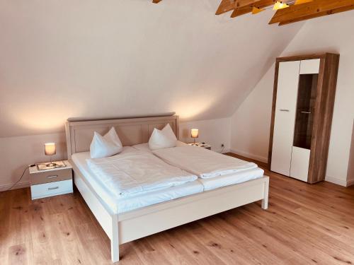 una camera con letto bianco e specchio di Ferienhaus Garz a Garz