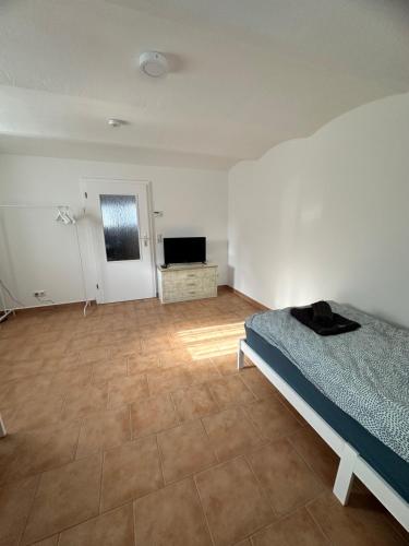 a bedroom with a bed and a television in it at Knuffige Ferienwohnung im Herzen von Haiger in Haiger