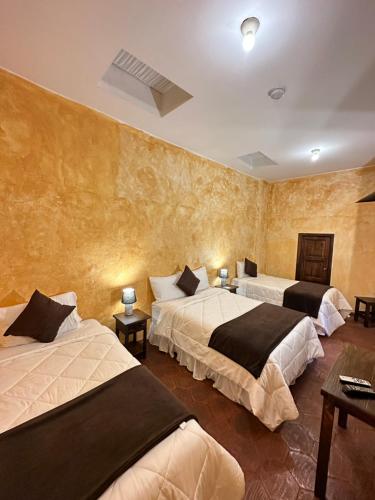dwa łóżka w pokoju z dwoma stołami w obiekcie NASS Central Garden w mieście Cuenca