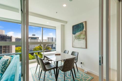 a dining room with a table and chairs and a window at Brand New! Luxe 3BR In Aotea Square I Zodiak Stays in Auckland