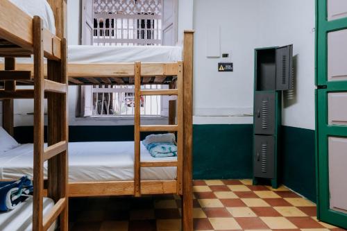a room with bunk beds and a television at Origen Hostel Jardín in Jardin