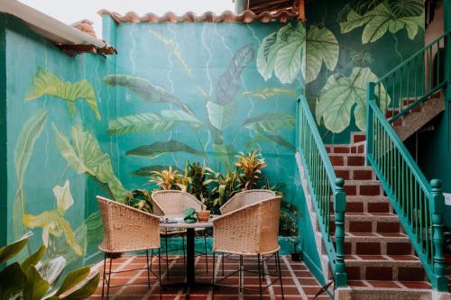 a room with two chairs and a wall with plants at Origen Hostel Jardín in Jardin