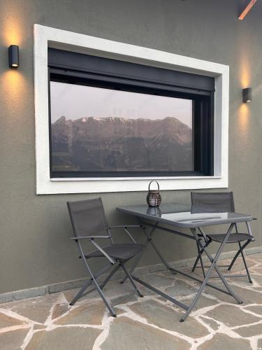 a table and two chairs in front of a window at ToVouno in Plaka