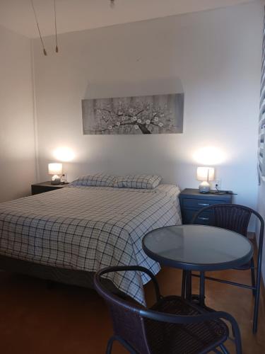 a bedroom with a bed and a table and two chairs at POSADA del MAR in Puerto Escondido
