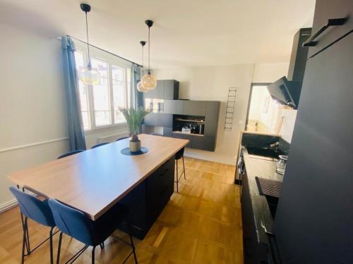 une cuisine avec une table en bois et des chaises bleues dans l'établissement Appartement vieux Tours 6 personnes, à Tours