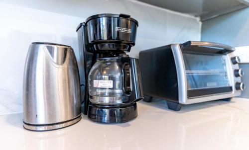 a coffee maker and a microwave on a counter at Faith's Villa Tobago in Diamond