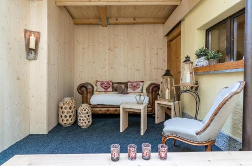 a porch with a bed and chairs and a table at Hotel Chesa Staila in La Punt-Chamues-ch