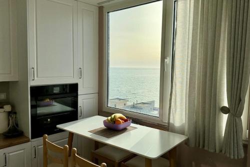 uma cozinha com uma mesa e uma janela com uma taça de fruta em BS Apartment 5 em Durrës