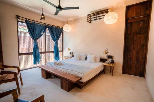 een slaapkamer met een groot bed en een groot raam bij Casa Mandarina downtown with pool in Mérida