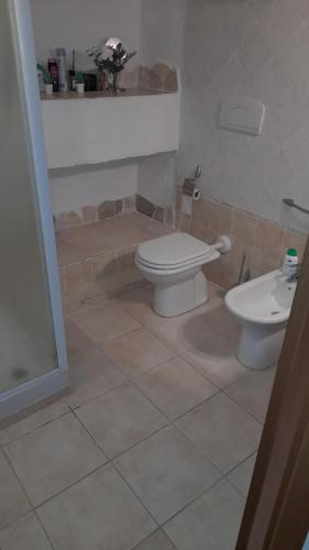 a bathroom with a toilet and a sink at Casa vacanze con terrazza panoramica vista mare in Portu Maga
