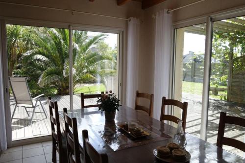 une salle à manger avec une table et une grande fenêtre dans l'établissement Gîte Océanite - Kerlouan, à Kerlouan
