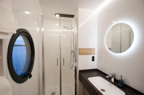 La salle de bains est pourvue d'un lavabo et d'un miroir. dans l'établissement Hausboot Moin Madita in exklusiver Lage, à Schleswig