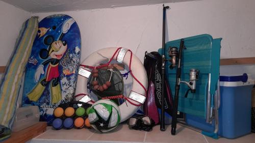 a room with surfboards and a doll on a shelf at Casa vacanze con terrazza panoramica vista mare in Portu Maga