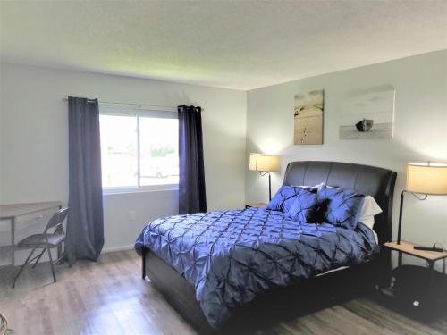 een slaapkamer met een bed met een blauw dekbed en een raam bij A1A Brownwaves in St. Augustine